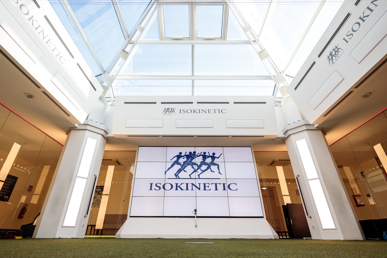 The glass-roofed training hall with artificial turf and a video wall